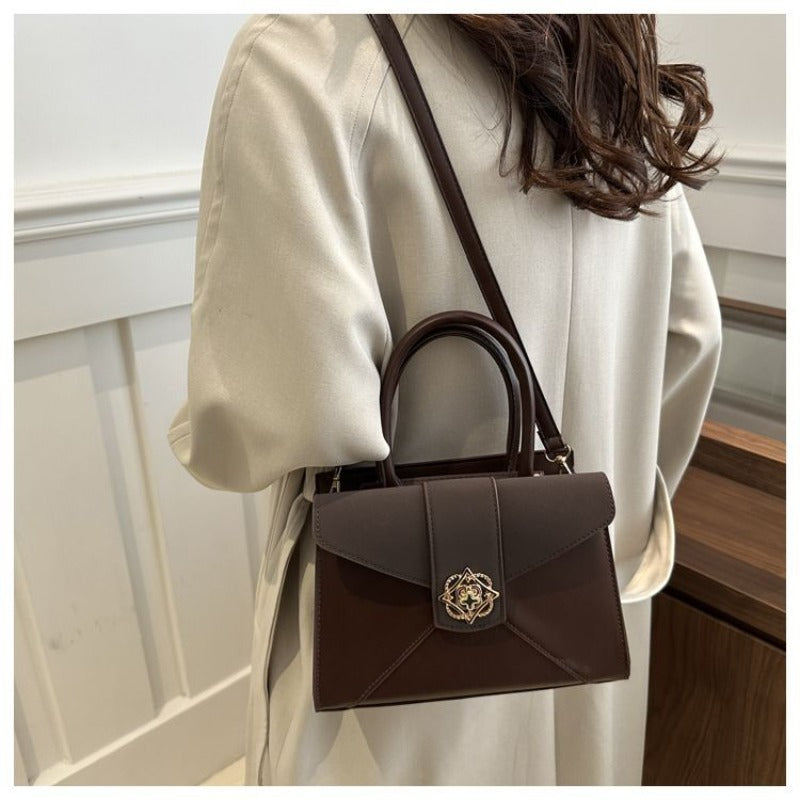 A Compact Shoulder Bag for Women Featuring a Square Lock Clasp And a Zipper System with an Additional Compartment, Ideal for Daily Commutes And Travel. This Multi-Colored Crossbody Bag Serves As a Versatile Everyday Handbag