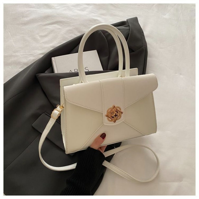 A Compact Shoulder Bag for Women Featuring a Square Lock Clasp And a Zipper System with an Additional Compartment, Ideal for Daily Commutes And Travel. This Multi-Colored Crossbody Bag Serves As a Versatile Everyday Handbag